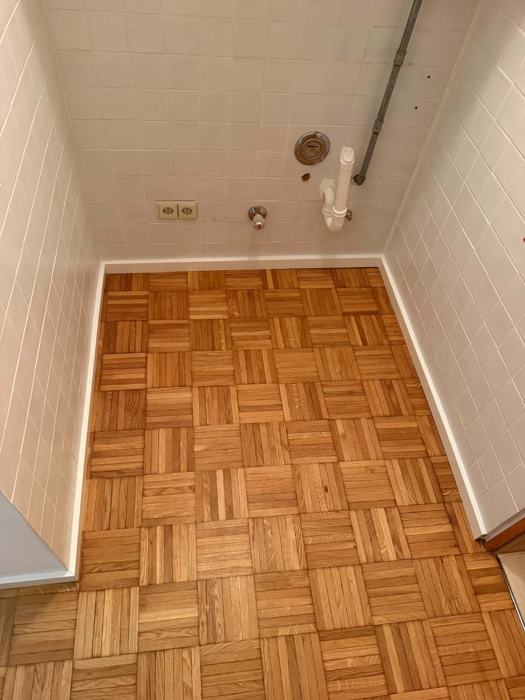 Mosaikparkett aus Eiche in einem kleinen gefliesten Raum
